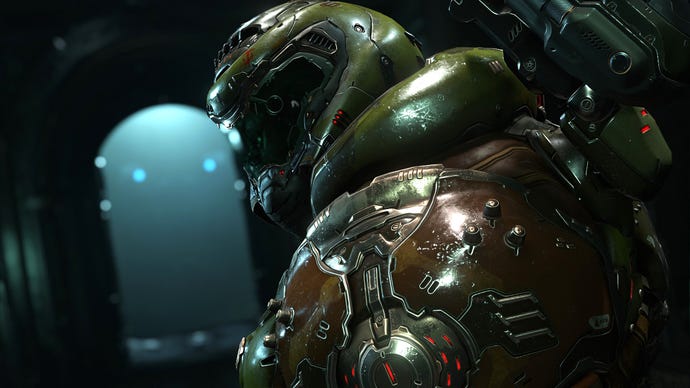The fabled Doom Slayer turns, over their shoulder, towards the camera. They wear their trademark bulbous, dark green armour, and their visored helm.