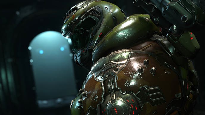The fabled Doom Slayer turns, over their shoulder, towards the camera. They wear their trademark bulbous, dark green armour, and their visored helm.