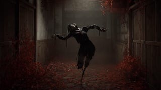 A scene from the Silent Hill f trailer showing a scarecrow-like figure resembling an awkwardly twisted Japanese school girl balanced on spindly limbs. It stands illuminated by a dim light in a hallway covered in blood-red blooms.